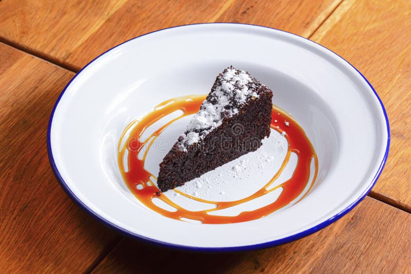 A slice of delicious chocolate cake. Piece of cake on a white plate with caramel. Sweet food. royalty free stock photography A slice of delicious chocolate cake. Piece of cake on a white plate with caramel. Sweet food. royalty free stock photography