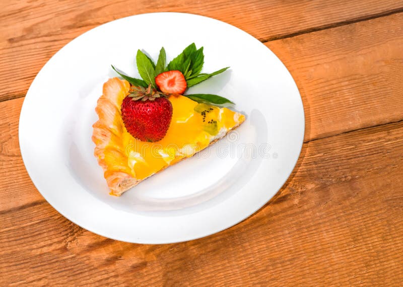Slice of fruit pizza with strawberries and mint