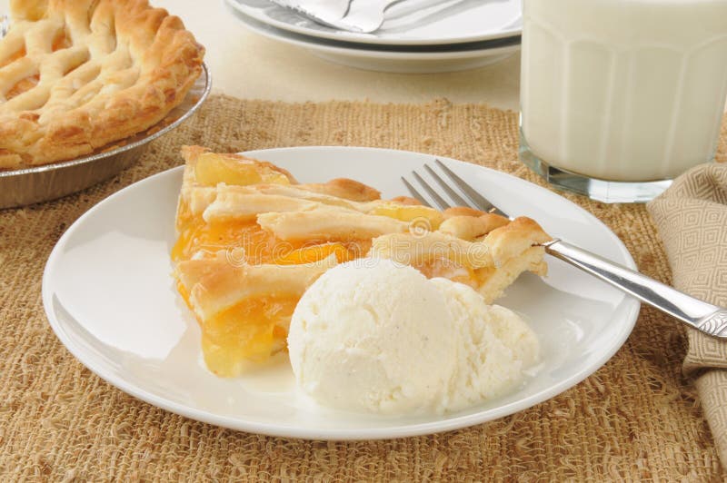 A slice of peach pie with vanilla ice cream. A slice of peach pie with vanilla ice cream