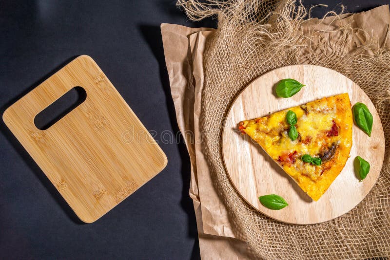 Slice of Pizza with Basil on a Wooden Board. Top View Flat Lay Stock