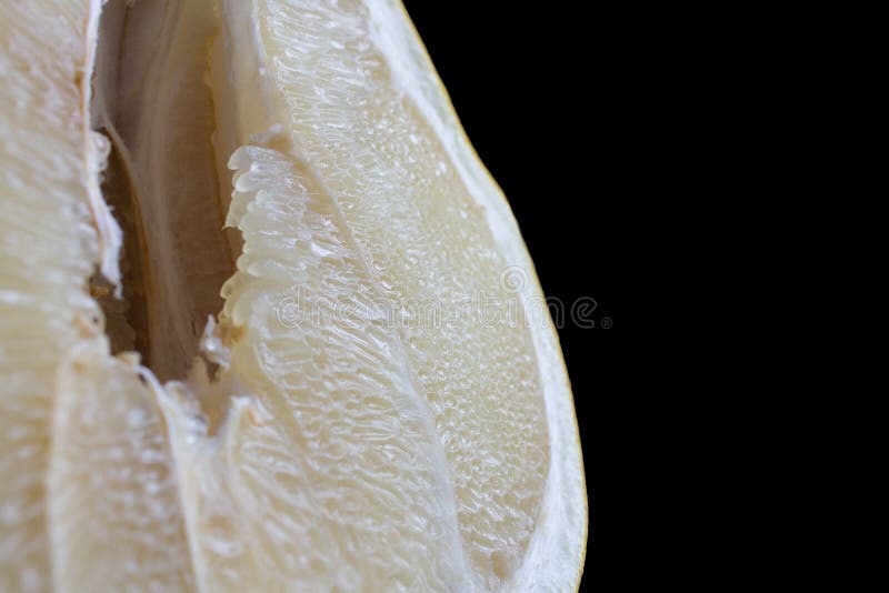 Slice of ripe fresh Pamela fruit with hole in pulp and juice shot close-up on a black background. stock photo Slice of ripe fresh Pamela fruit with hole in pulp and juice shot close-up on a black background. stock photo