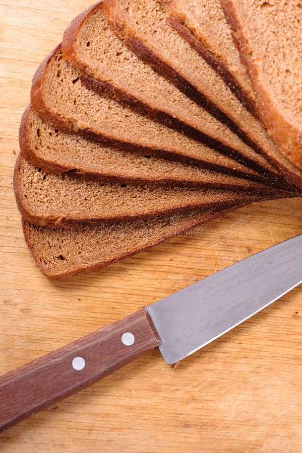 Sliced bread on a wooden cutting board and knife