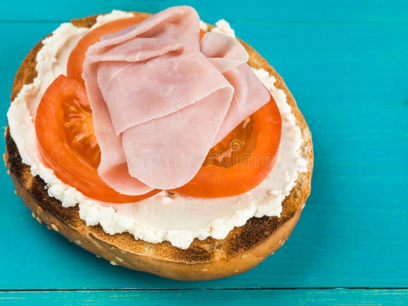 Sliced Cold Ham Tomato and Soft Cheese Sesame Bagel royalty free stock photo