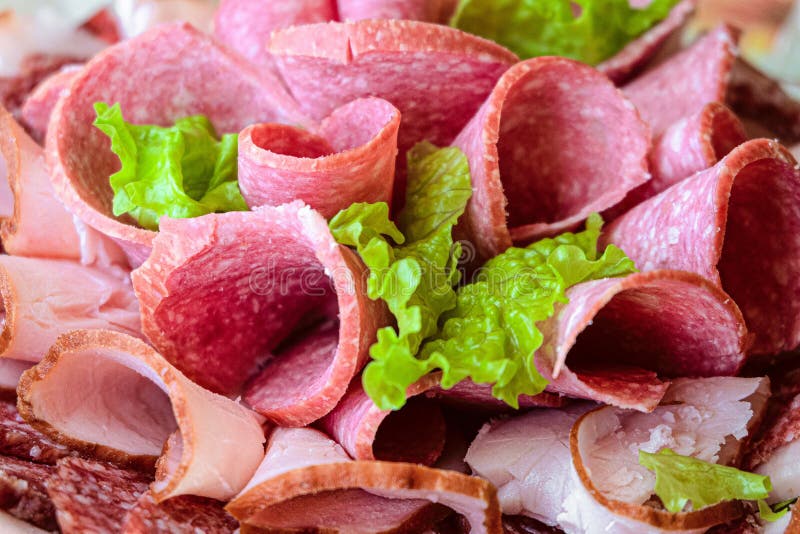 Sliced Ham and Raw Smoked Sausage Rolls with Lettuce Leaves Stock Image