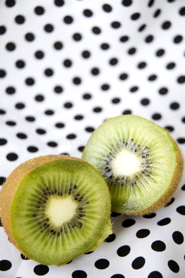 Sliced kiwi fruit on polka dots