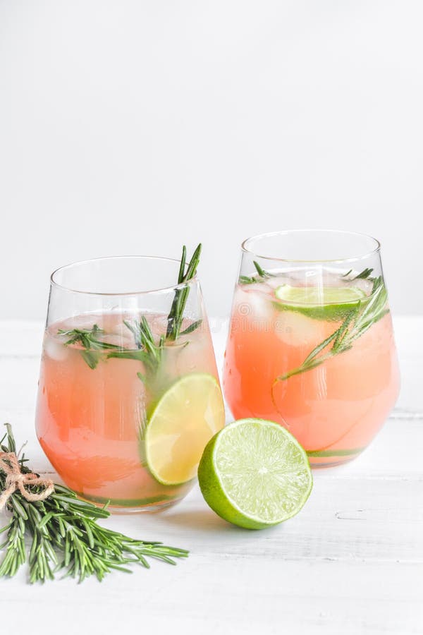 Sliced Lime, Rosemary and Natural Juice in Glass on White Table