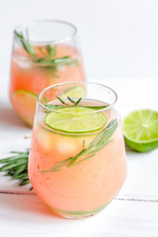 Sliced Lime, Rosemary and Natural Juice in Glass on White Table
