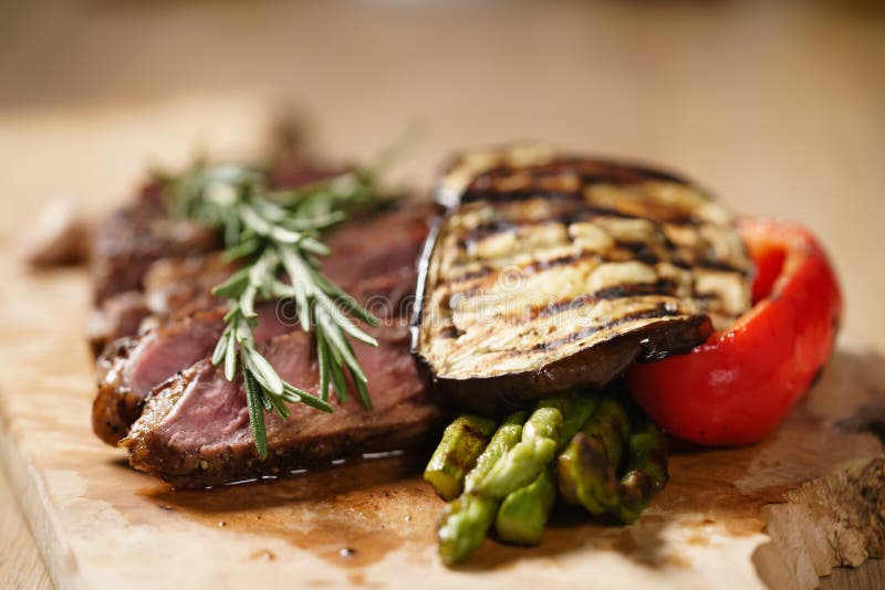 Sliced Medium Rib Eye Steak with Grilled Vegetables Stock Photo Image