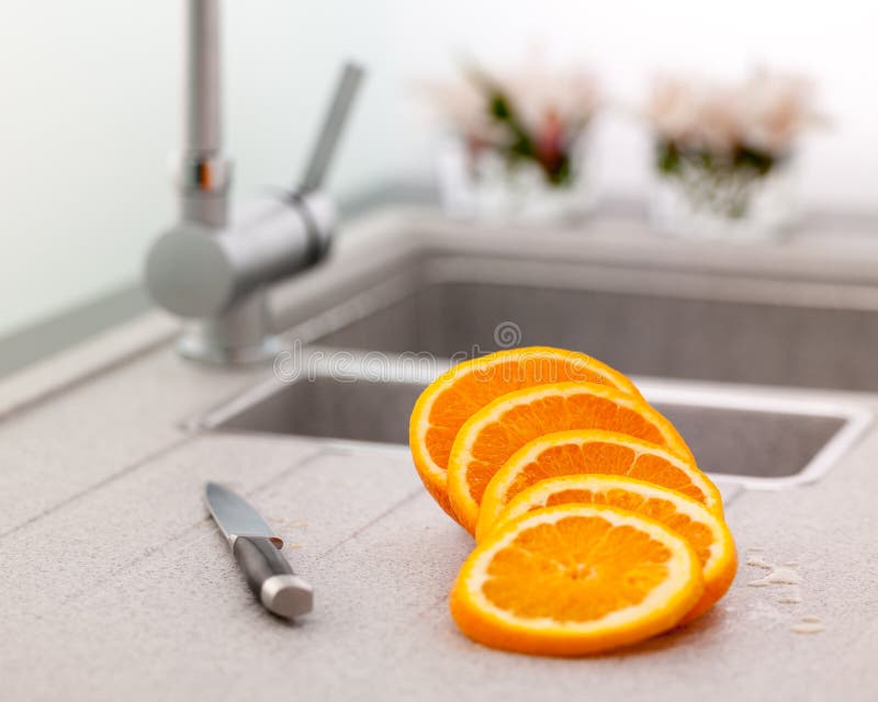 Sliced orange and knife on kitchen sink