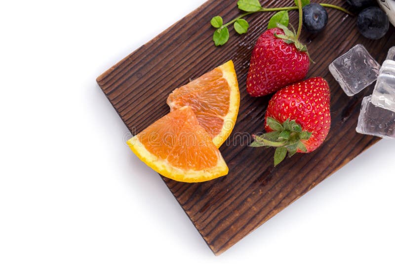 Sliced Orange, Strawberry and Blueberry on a wooden plate with i