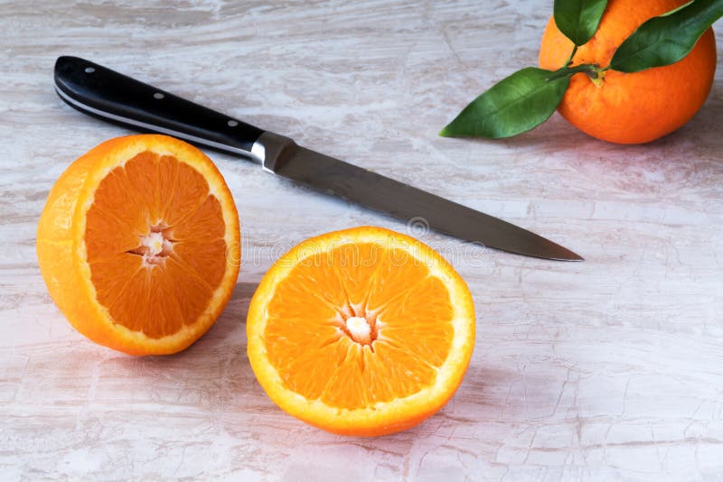 Sliced Oranges on White Marble with Knife