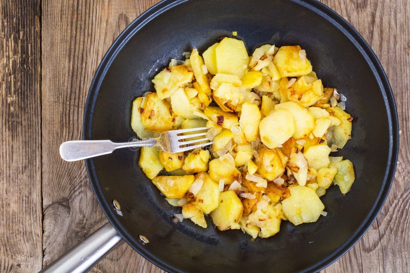 Sliced Potatoes Fried with Onions in Frying Pan on Wooden Background ...