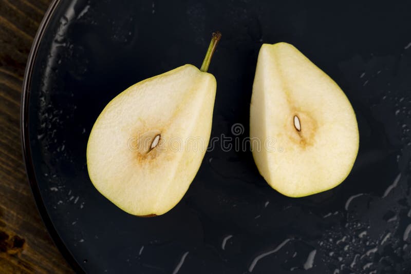 Sliced ripe pears on a blue ceramic bowl on the table stock photos