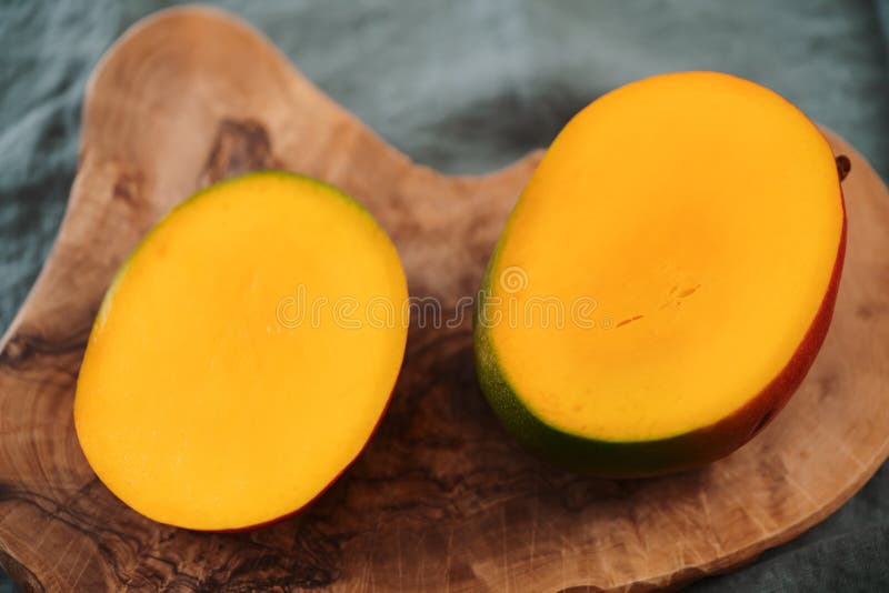 Sliced ripe red mango on olive wood board royalty free stock photography