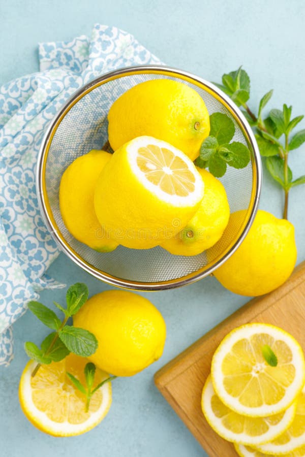 Sliced and whole lemons with mint stock images