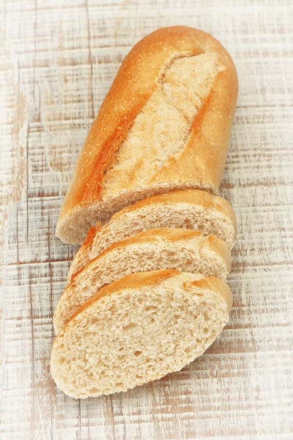 Sliced ​​pieces of fresh bread on the board texture.
