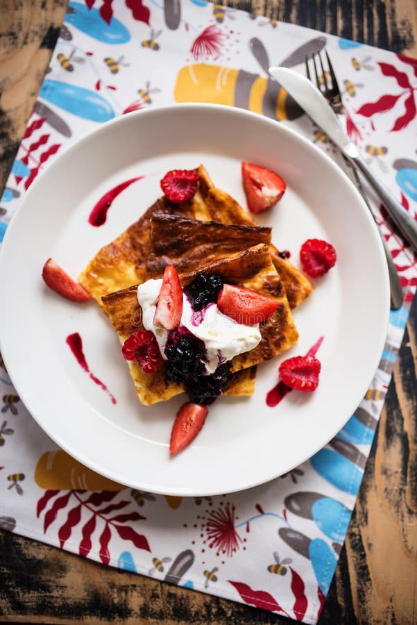 Slices of finnish pancake served with cream and fruits