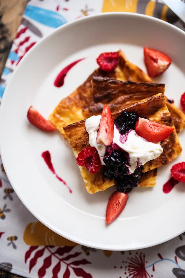 Slices of finnish pancake served with cream and fruits