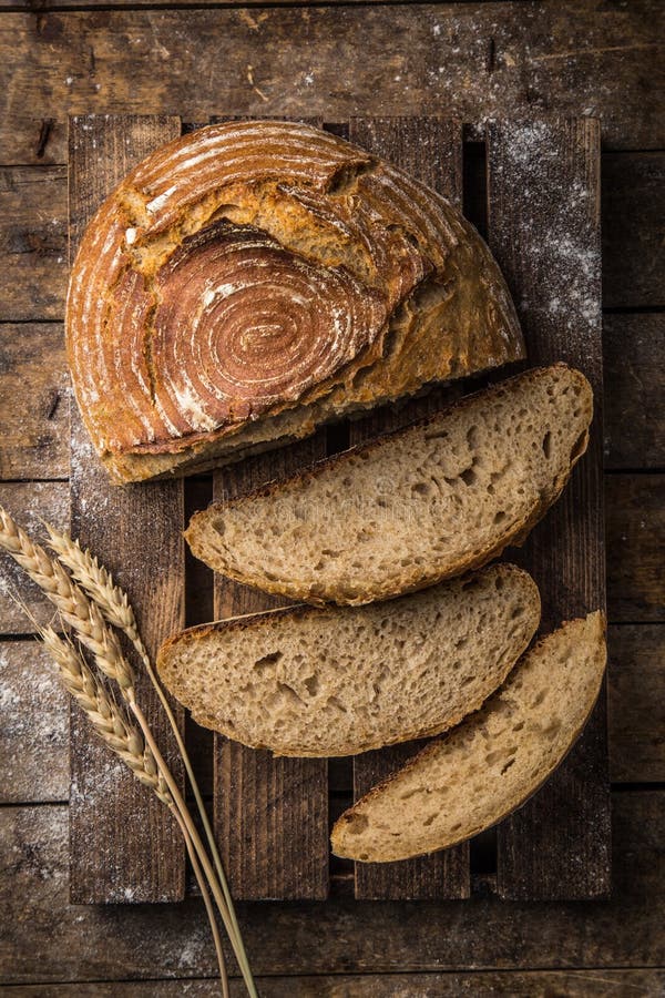 Slices of fresh baked sour dought bread on rustic wood background, top view. Dought stock images, royalty-free photos and pictures