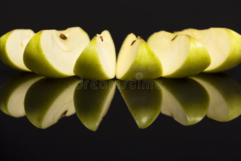 Slices of fresh green apples on black background.