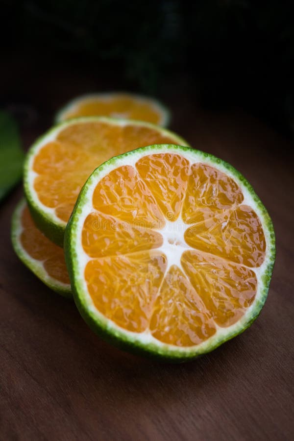 Slices Of Fresh Tangerine Isolated On A Wooden Background Low Key