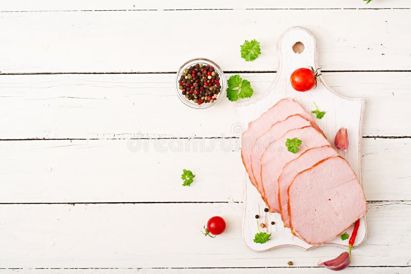 Slices of ham on white wooden background stock images Slices of ham on white wooden background stock images