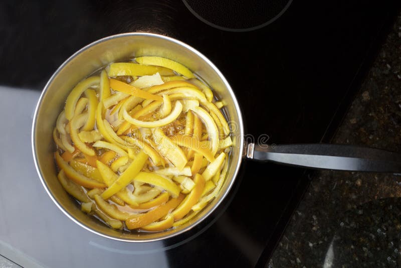 Orange and lemon peels slices and placed in a pan of boiling wather and sugar to make candied peels. Orange and lemon peels slices and placed in a pan of boiling wather and sugar to make candied peels