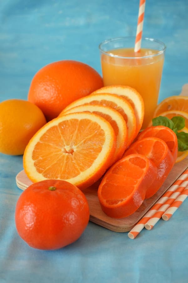 Slices of orange, mandarin and lemon and yellow juice in a glass