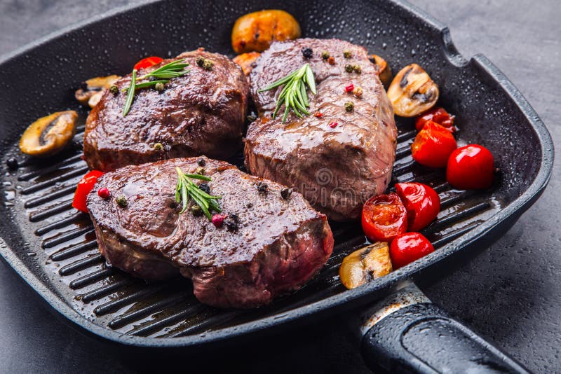 Slices of sirloin beef steak on meat fork on concrete background