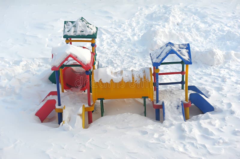 A children's playground and a slide in the snow. A children's playground and a slide in the snow