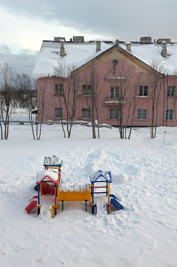 A children's playground and a slide in the snow. A children's playground and a slide in the snow