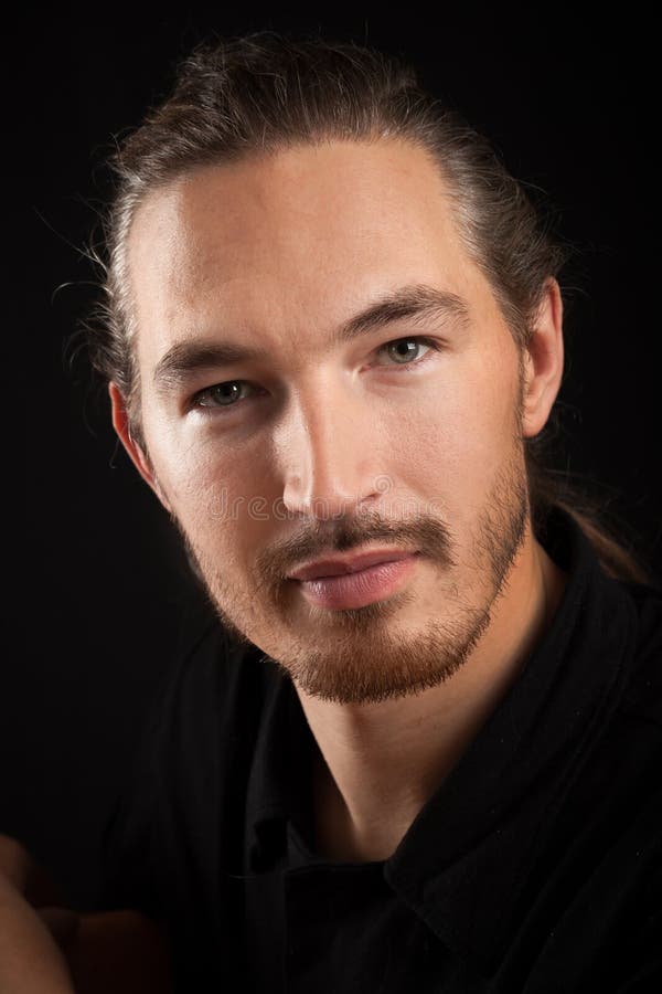 Slightly smiling young smart Oriental man portrait on black back royalty free stock photos Slightly smiling young smart Oriental man portrait on black back royalty free stock photos