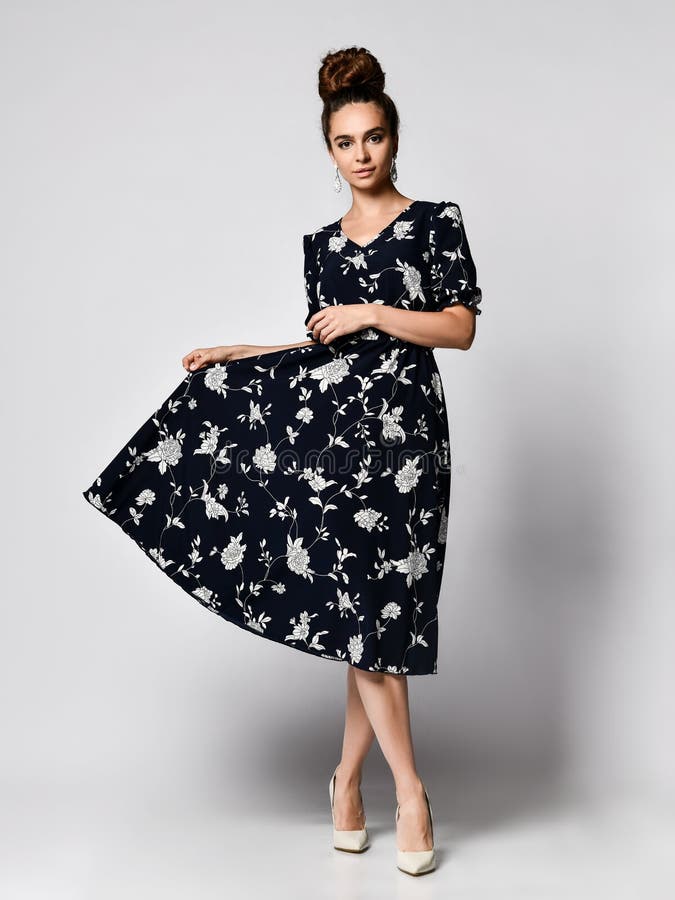 Spectacular Girl with a High Hairstyle in a Black Dress with a White Floral Print on High Heels. Holding a Skirt Over the Edge Stock Photo - Image of enjoy, femininity: 163640666 Spectacular Girl with a High Hairstyle in a Black Dress with a White Floral Print on High Heels. Holding a Skirt Over the Edge Stock Photo - Image of enjoy, femininity: 163640666