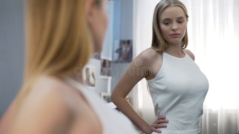 Teenager girl looking at mirror and checking her breast Stock Photo - Alamy