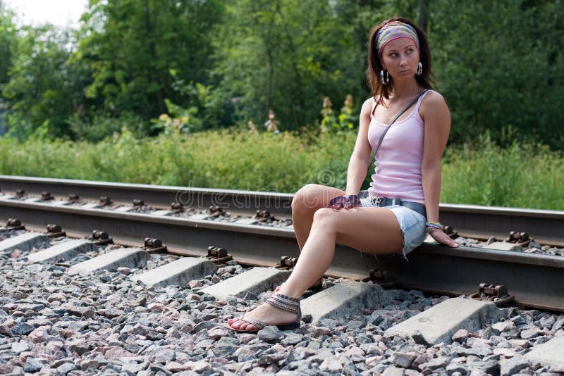 Slim lady is sitting on a railroad — Stock Photo 