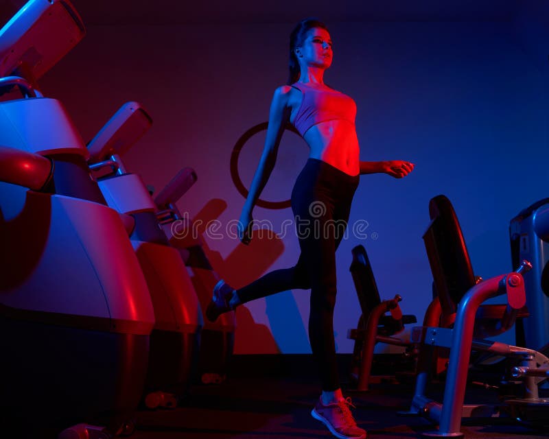 Slim Woman Jumping Between Rows Of Exercise Machines Stock Image