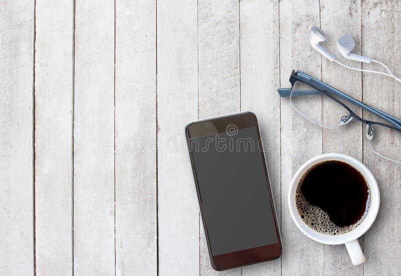 Slimme telefoon en kop van koffie op oude houten achtergrond met cop stock foto Slimme telefoon en kop van koffie op oude houten achtergrond met cop stock foto
