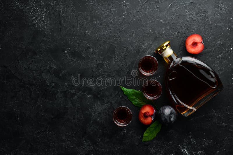 Slivovica - plum vodka, plum brandy in a bottle on a black stone table. Glasses with alcoholic beverage. Top view. Free space for your text royalty free stock images Slivovica - plum vodka, plum brandy in a bottle on a black stone table. Glasses with alcoholic beverage. Top view. Free space for your text royalty free stock images