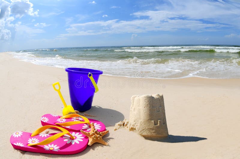 Pretty sand castle on seashore by beach accessories. Pretty sand castle on seashore by beach accessories