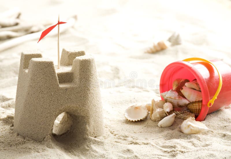 Sand castle and bucket full of shells. Sand castle and bucket full of shells