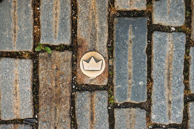 Slovakia, Bratislava. Brass crown marker in cobblestone streets show location of the coronation walk. Old town. Top view