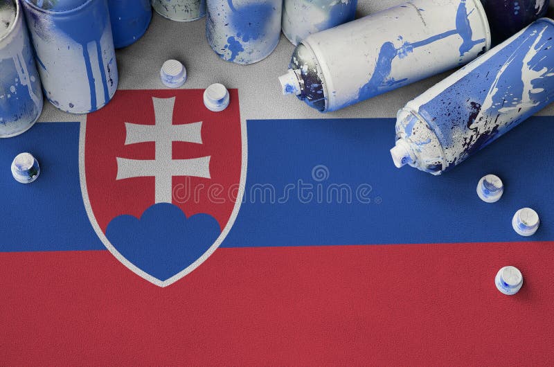 Slovenská vlajka a málo používané aerosólové spreje na maľovanie graffiti. Koncept street art kultúry