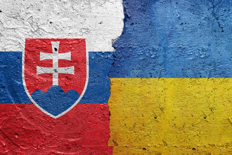 Slovensko a Ukrajina - Popraskaná betonová zeď natřená slovenskou vlajkou vlevo a ukrajinskou vlajkou vpravo fotografie