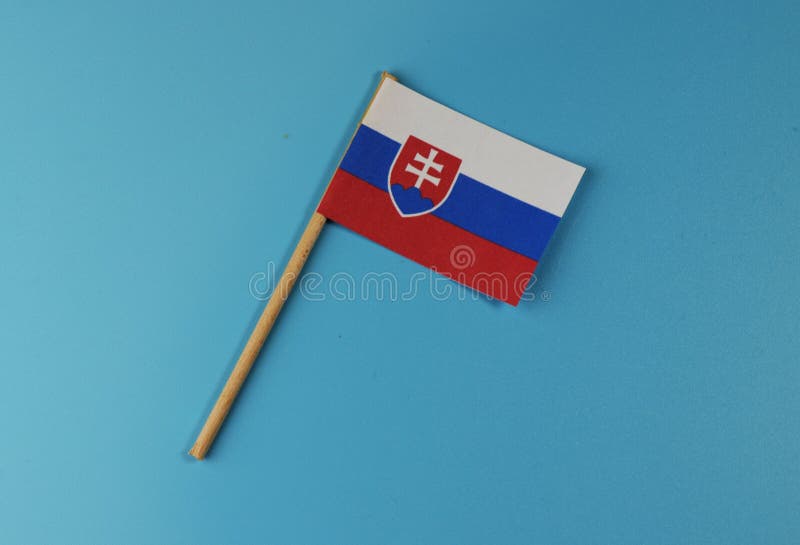 Slovenská vlajka ležící na modrém pozadí