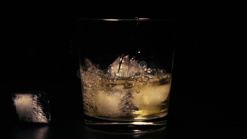 Slow mo whiskey in glass with ice