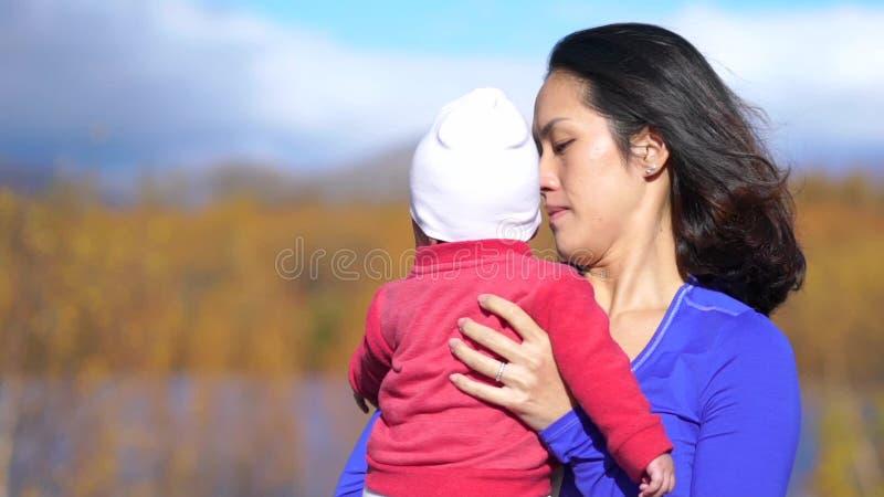 Slow motion of Asian Mother and baby outdoors in a park