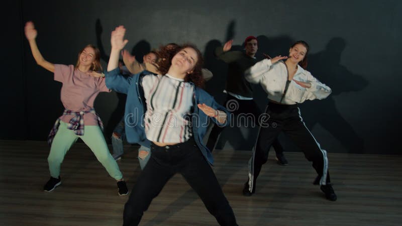 Slow motion di un gruppo di giovani che ballano insieme in danza scura