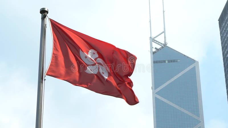 Slow motion flag of Hong Kong waving in the wind with Bank of China Tower