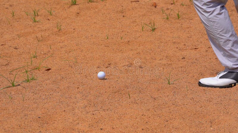 Slow motion golfer hitting swing golf ball on sand bunker