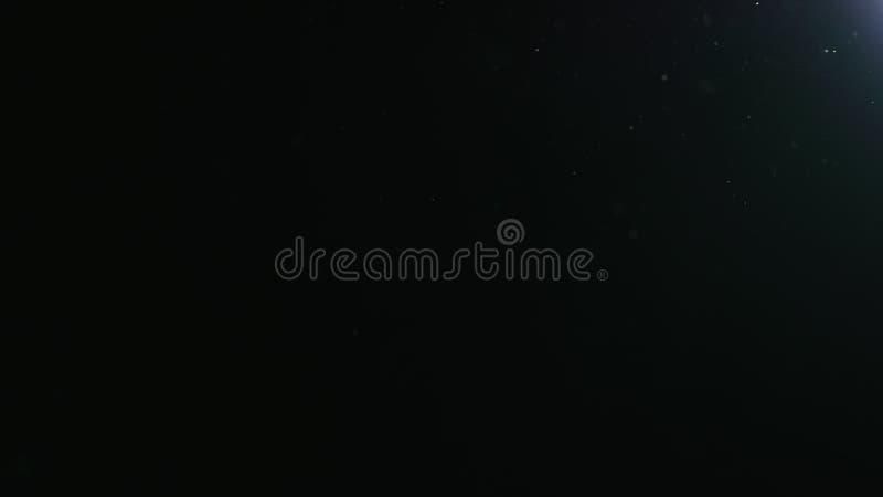 Slow motion natural dust particles float in air on black background stock video footage